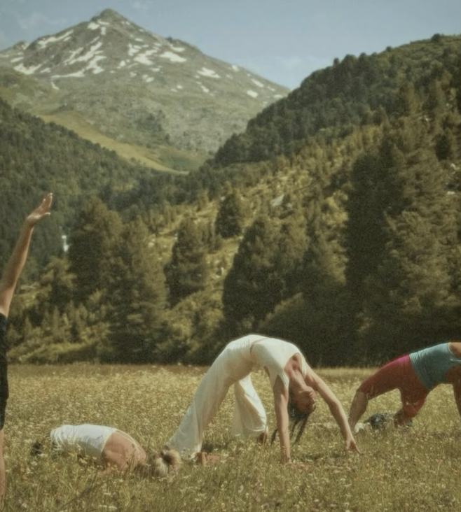 Una persona pratica yoga in un prato al mattino